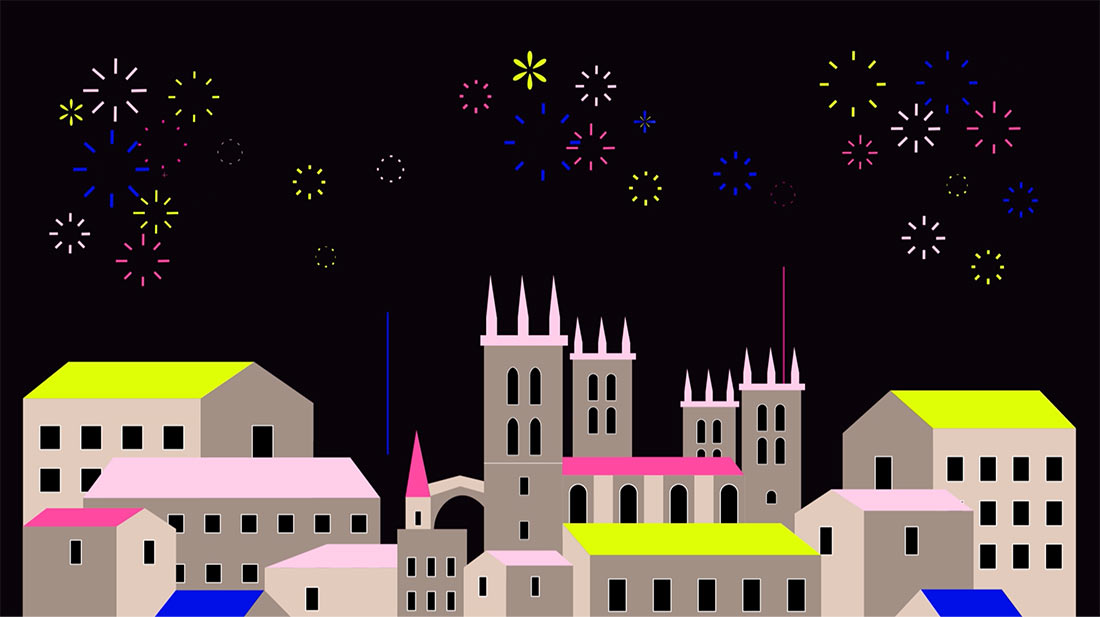 Des feux d'artifice colorés illuminent le ciel nocturne au-dessus de la ville de Montpellier avec la grande cathédrale et des bâtiments aux toits colorés.