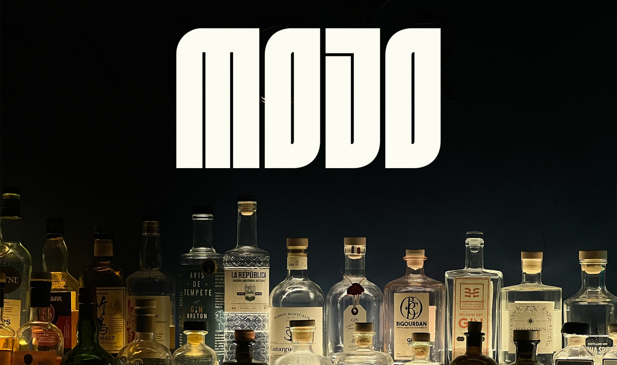 Logo de la marque de gin Mojo, placée au-dessus d'une collection de bouteilles d'alcool, créant une ambiance de bar sophistiqué.