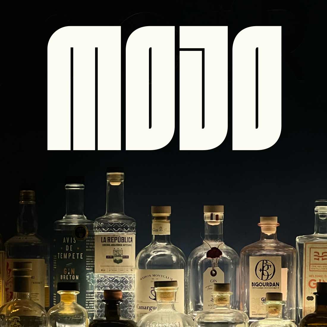 Projets design graphique - Le Mojo. Logo de la marque de gin Mojo, placée au-dessus d'une collection de bouteilles d'alcool, créant une ambiance de bar sophistiqué.